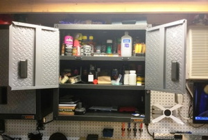 open doors on a garage cabinet full of chemicals