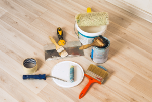 paint rollers, brushes, and other supplies on the floor