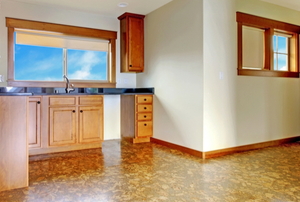 cork floor in kitchen with wood cabinets and beige walls