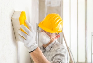 A man works on plaster board.