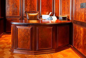 Matching wood veneered desk and walls.