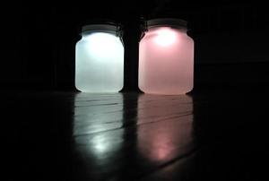 One mason jar with plain bluish white light , and one jar with a reddish tinted color.