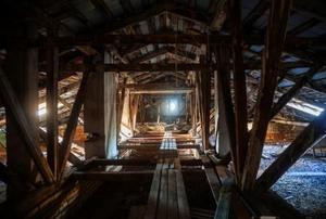 A darkly-lit attic space, sparsely covered with floorboards.