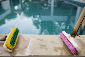 A pool deck with a couple brushes.