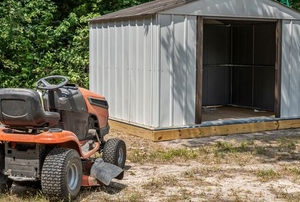 riding lawn mower near open storage shed