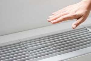 a hand above an air conditioning vent
