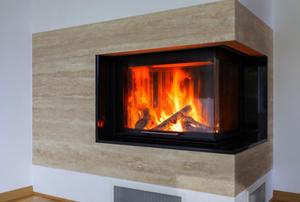 An ultra-modern fireplace with a fire going.