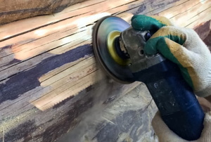 hands sanding log with power tool