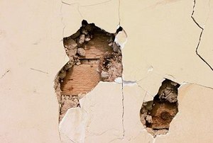 holes and cracks in a plaster wall