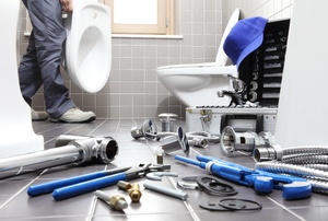 Plumbing tools near a toilet.