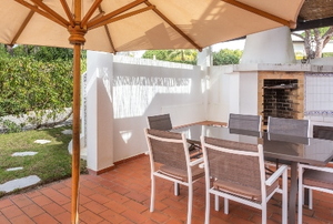 a patio with umbrella, table, and chairs