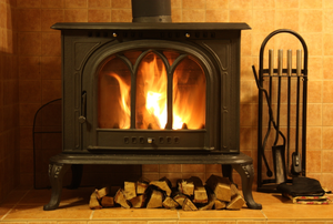 a wood stove with wood beneath it