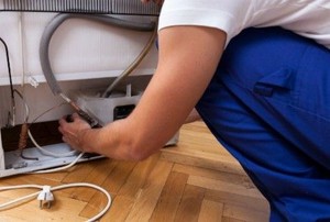 man working on fridge electronics