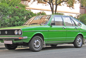 A green car on a  road.