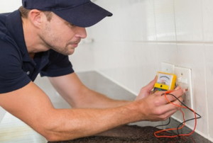 a man checking the voltage on an outlet with a multimeter