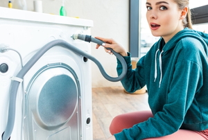 woman next to the back of a washing machine