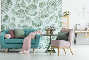 a bright living room with smashing green wallpaper and comfy furniture