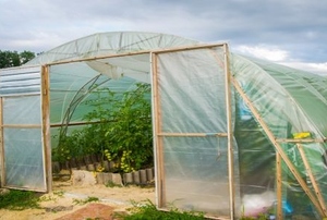 a greenhouse made from wooden frames and thin plastic