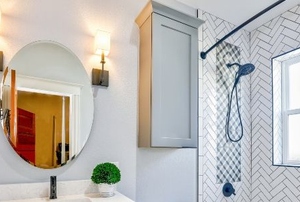 bathroom with drywall, mirror, and shower