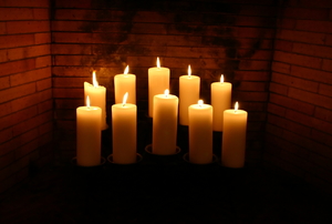 A grouping of candles in a fireplace.