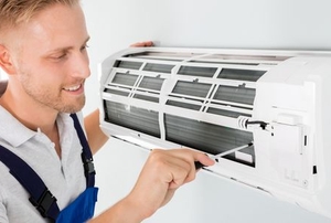 man adjusting wall mounted AC fan