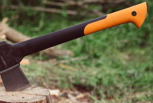 camping axe in wood log