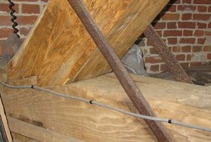 a triangular joint between two beams against a brick wall.