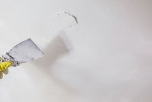 A man does faux wall painting.