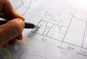 A man works on blueprints.