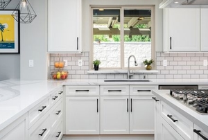 bright Shaker style kitchen with simple cabinets and large window