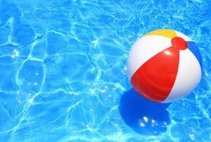 A beautiful pool with a floating beach ball, waiting to be splashed into.