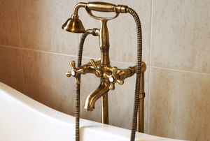 bronze bathtub faucet in front of tile