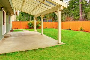 A concrete backyard patio with partial cover.