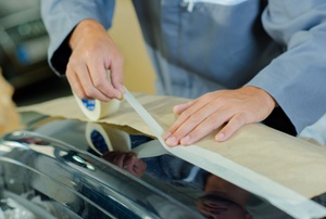 A man uses masking tape.