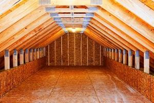 Looking down the length of a long, empty, unfinished attic.