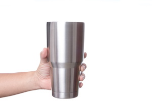 A man holds a stainless steel cup.