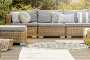 backyard seating area with handsome wicker couch, chairs, and cushions