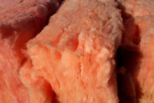 An extreme close-up of a pink wedge of fiberglass insulation.