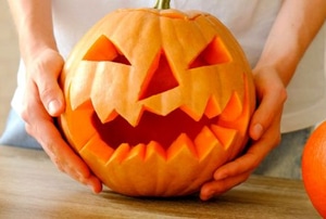 hands holding pumpkin carved for halloween