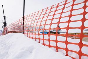 Orange snow fencing surrounded by snow
