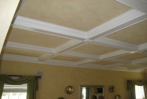 white beams surrounded by trim on tan ceiling