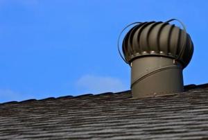 A mushroom-shaped gable vent against a blue sky.