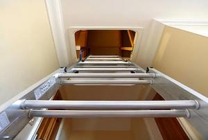 Looking up a ladder toward the attic entrance.