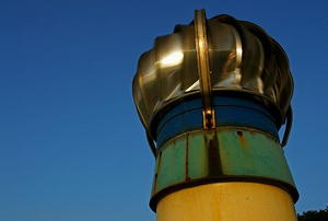 Close-up of a turbine vent spinning against a blue sky.