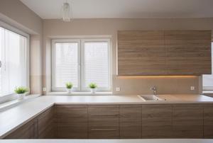 A minimalist kitchen with light coming in through the windows.