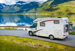 RV driving on beautiful road trip by lake