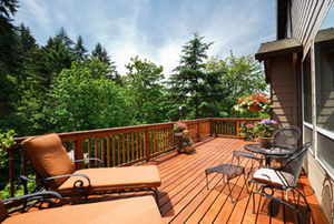 The afternoon sun shines on a back deck overlooking a slope.