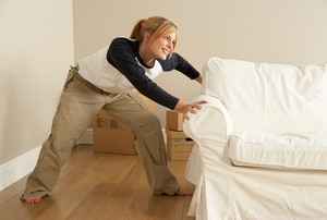 woman moving heavy couch alone