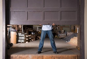 man lifting a brown garage door