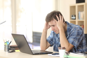 Man looking stressed staring at a computer